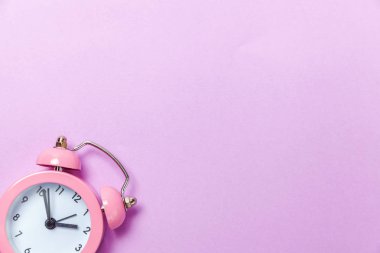 İki Yataklı çan vintage klasik çalar saat göl kenarında mor menekşe pastel renkli arka plan üzerinde zil. Yaşam süresi saat sabah gece iyi dinlen uyanık kavramı uyandır. Düz yatıyordu üstten görünüm kopya alanı