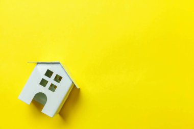Sade bir şekilde izole sarı renkli şık modern moda arka plan üzerinde beyaz minyatür oyuncak ev tasarım. Mortgage Emlak Sigorta rüya ev concept. Düz yatıyordu üstten görünüm kopya alanı