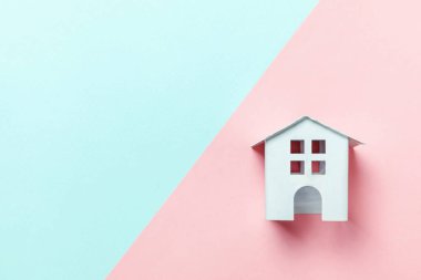Sadece tasarım mavi, pembe pastel renkli trendy geometrik arka plan izole bir minyatür beyaz oyuncak ev. Mortgage Emlak sigorta rüya ev concept. Düz yatıyordu üstten görünüm kopya alanı