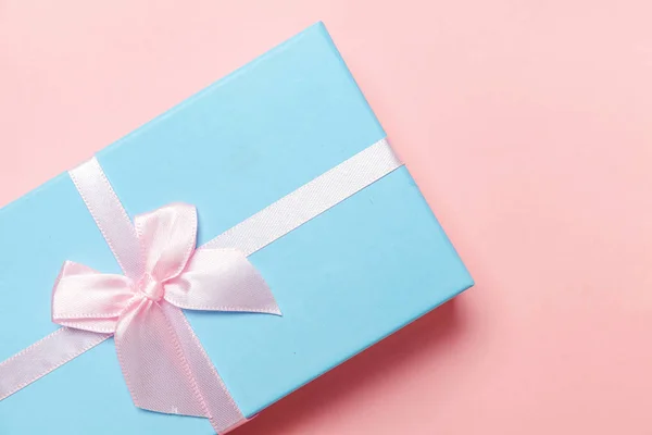 Christmas New Year birthday valentine celebration present romantic concept. Small gift box wrapped blue paper isolated on pink pastel colorful trendy background. Flat lay top view copy space