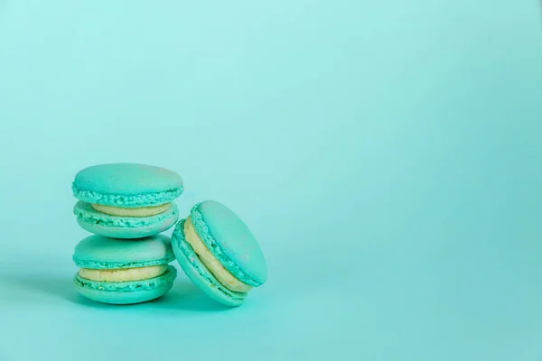 甘いアーモンド色のユニコーンブルーのマカロンまたはマカロンデザートケーキは 流行の青いパステルの背景に隔離されています フランスの甘いクッキー 最小限の食品パン屋のコンセプト スペースのコピー — ストック写真