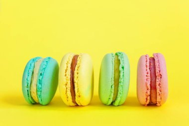 Tatlı badem renkli tek boynuzlu at pembe, mavi, yeşil badem kurabiyesi ya da modern moda arka planında izole edilmiş kurabiyeli pasta. Fransız kurabiyesi. Asgari gıda fırını konsepti. Boşluğu kopyala