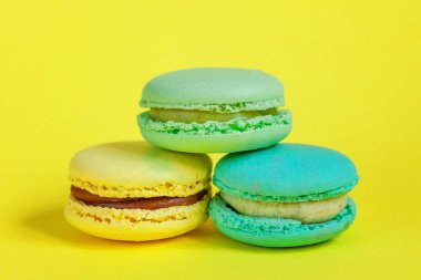 Tatlı badem renkli tek boynuzlu at pembe, mavi, yeşil badem kurabiyesi ya da modern moda arka planında izole edilmiş kurabiyeli pasta. Fransız kurabiyesi. Asgari gıda fırını konsepti. Boşluğu kopyala