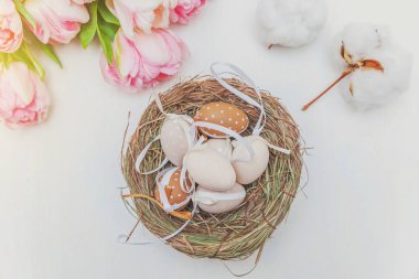 Paskalya yumurta yuva yosun pamuk ve pembe taze Lale kokulu beyaz rustik ahşap zemin üzerinde yosun pamuk ve pembe taze Lale kokulu beyaz rustik ahşap arka plan Paskalya yumurta yuvada üzerinde