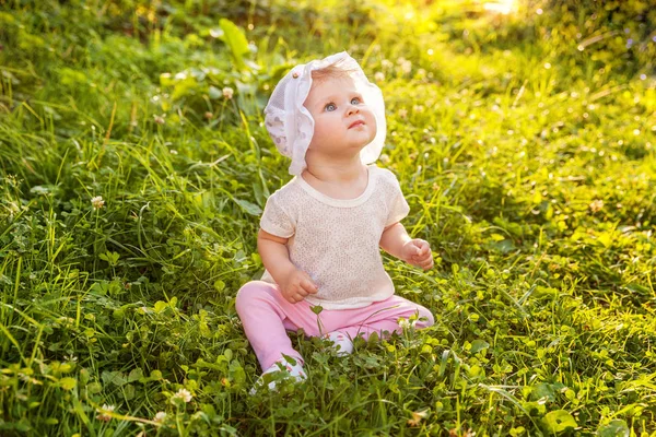 Édes boldog kis baba lány ül a fűben park, kert, rét — Stock Fotó