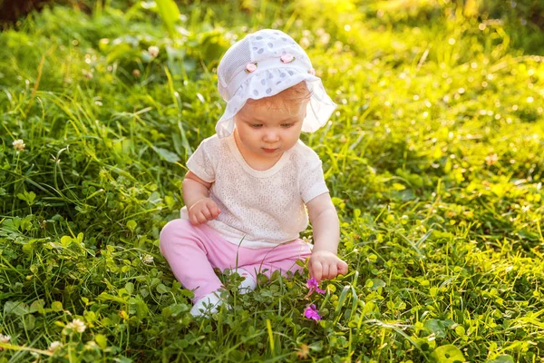 Édes boldog kis baba lány ül a fűben park, kert, rét — Stock Fotó