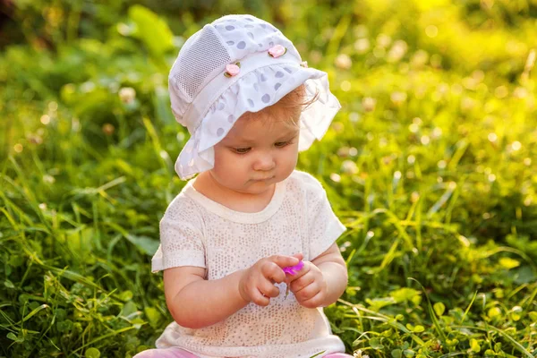 Édes boldog kis baba lány ül a fűben park, kert, rét — Stock Fotó