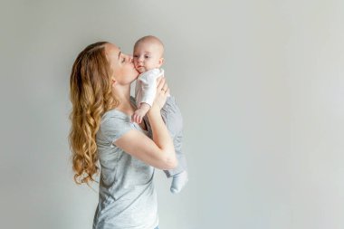Yeni doğmuş çocuğunu tutan genç anne