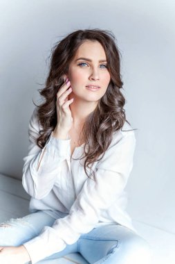 Parlak oda beyaz duvara oturan kız