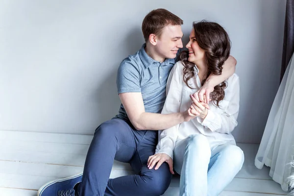 Romantic sexy couple in love having nice time together. Young woman hugging boyfriend, white background