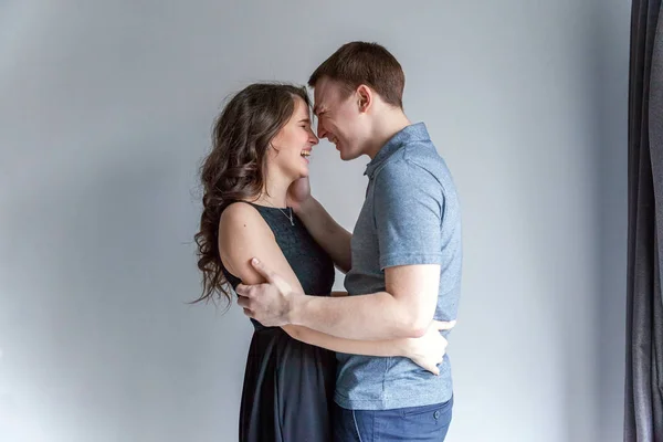 Romantic sexy couple in love having nice time together. Young woman hugging boyfriend, white background