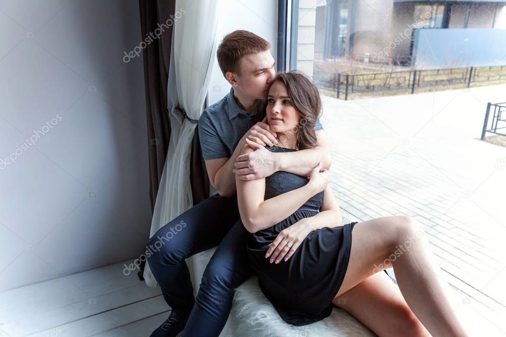 Romantic sexy couple in love having nice time together. Young woman hugging boyfriend, white background