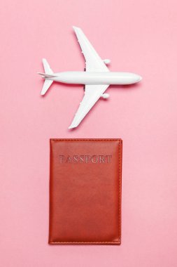 En az basit düz yatıyordu seyahat macera gezi konsepti ile uçak ve pasaport pembe pastel trendy modern arka plan üzerinde
