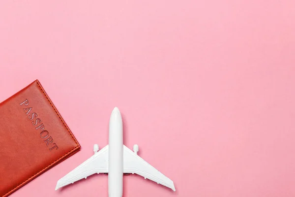 Mínimo simple plano lay viaje aventura concepto de viaje con avión y pasaporte en rosa pastel moderno fondo de moda — Foto de Stock