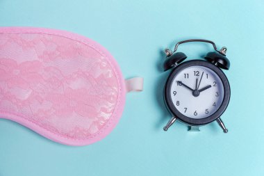 Uyku maskesi ve mavi arka plan çalar saat