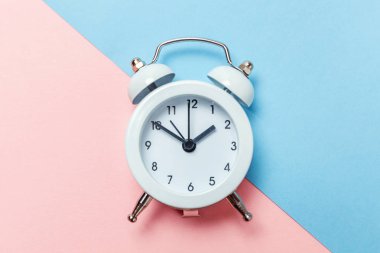 Vintage çalar saat göl kenarında mavi ve pembe pastel arka plan üzerinde