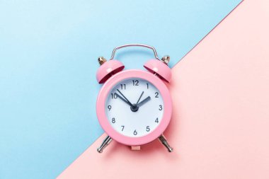 Vintage çalar saat göl kenarında mavi ve pembe pastel arka plan üzerinde