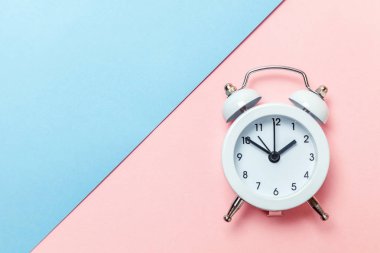 Vintage çalar saat göl kenarında mavi ve pembe pastel arka plan üzerinde