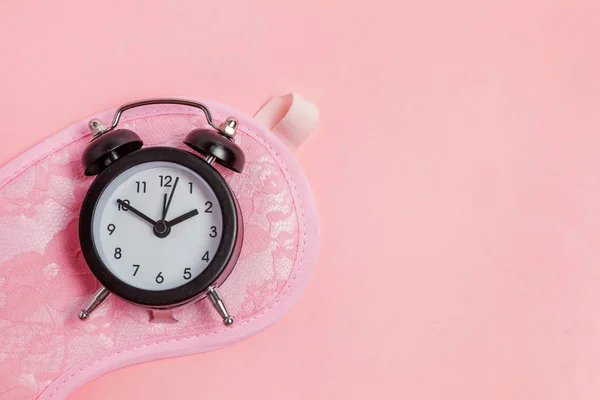 Slapende masker en wekker op roze achtergrond — Stockfoto