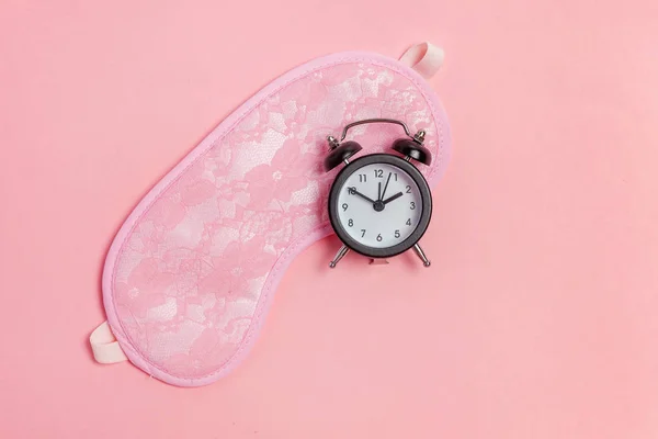 Μάσκα ύπνου και ξυπνητήρι σε ροζ φόντο — Φωτογραφία Αρχείου