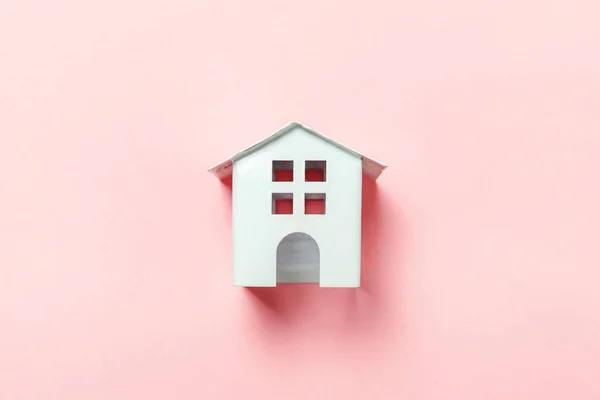 Miniatur-weißes Spielzeughaus auf rosa Pastell Hintergrund — Stockfoto