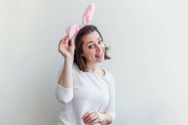Mutlu Paskalya tatil kutlama bahar kavramı. Beyaz arka plan üzerinde izole Paskalya gününde tavşan kulakları giyen genç kadın