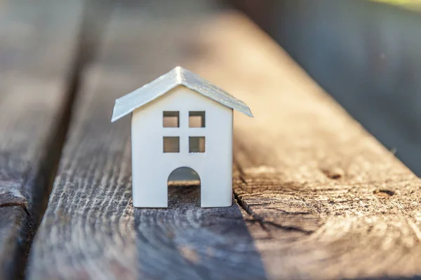 Miniaturowe białe zabawka modelu dom w drewniane tła. Eco Village, streszczenie tło środowiska — Zdjęcie stockowe