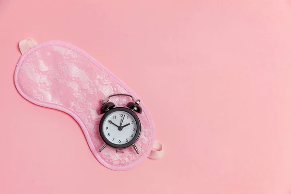 アイマスクとピンクの背景の目覚まし時計 — ストック写真