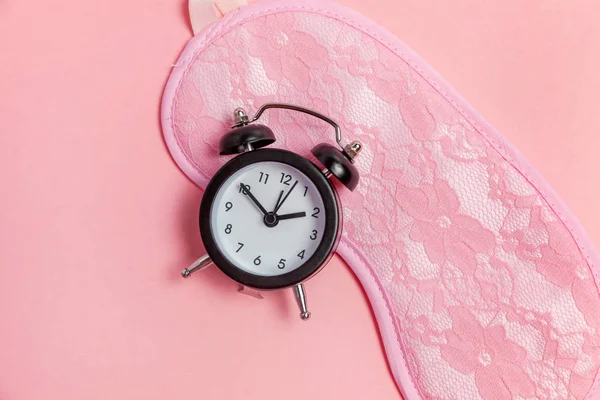 Спляча маска і будильник на рожевому фоні — стокове фото
