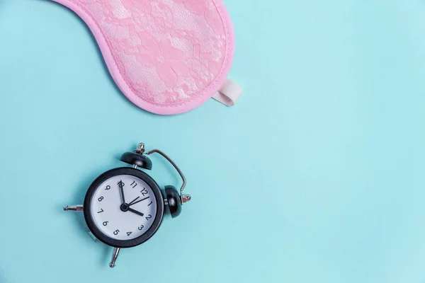 Máscara de dormir e despertador no fundo azul — Fotografia de Stock