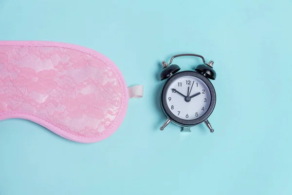 Slapende masker en wekker op blauwe achtergrond — Stockfoto