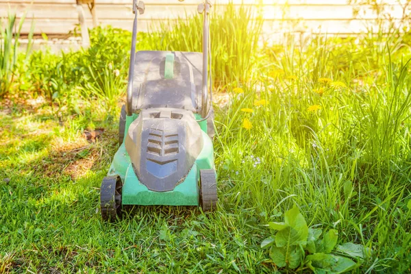 뒷마당에서 푸른 잔디를 절단 하는 잔디 깎는 기계 — 스톡 사진