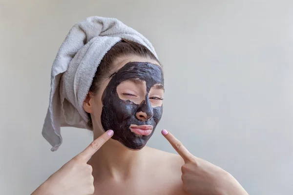 Kvinna som tillämpar svart närande mask på ansikte — Stockfoto