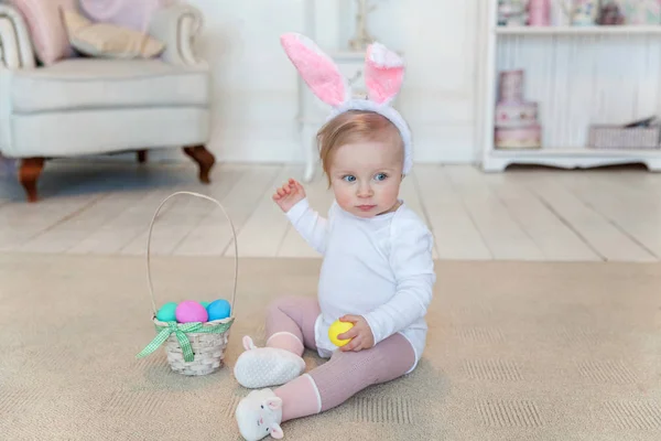 Petite fille enfant portant des oreilles de lapin le jour de Pâques et jouant avec des œufs peints — Photo