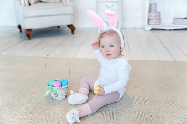 Kind meisje bunny oren dragen op Paasdag en spelen met beschilderde eieren — Stockfoto