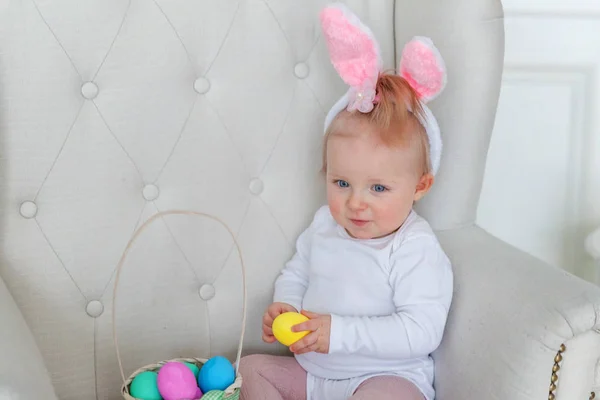 Bambina bambina che indossa orecchie di coniglio il giorno di Pasqua e giocare con uova dipinte — Foto Stock
