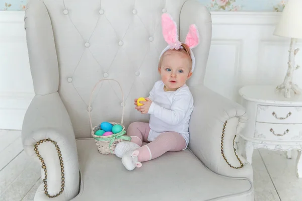 Bambina bambina che indossa orecchie di coniglio il giorno di Pasqua e giocare con uova dipinte — Foto Stock