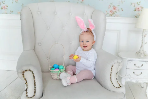 Bambina bambina che indossa orecchie di coniglio il giorno di Pasqua e giocare con uova dipinte — Foto Stock