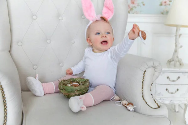 Lilla barnflickan bär bunny öron på påskdagen och leker med målade ägg — Stockfoto