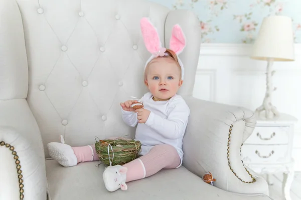 Mała dziewczynka dziecko sobie uszy królika na Wielkanoc i grając z pisanki — Zdjęcie stockowe