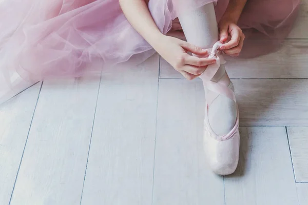 Ballerine mains met pointes chaussures sur la jambe en classe de danse — Photo