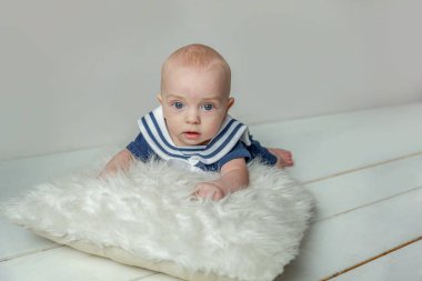 Erkek bebek bebek yastık beyaz yatak odası arka plan üzerinde yatıyor