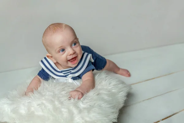 Infant baby boy lies on pillow on white bedroom background — Stock Photo, Image