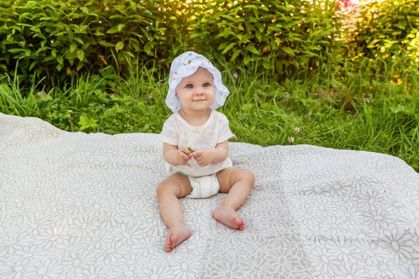 Sweet happy little baby girl sitting on grass in park, garden, meadow — Stock Photo, Image