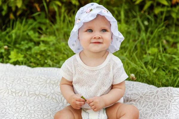 Dulce niña feliz sentado en la hierba en el parque, jardín, prado —  Fotos de Stock