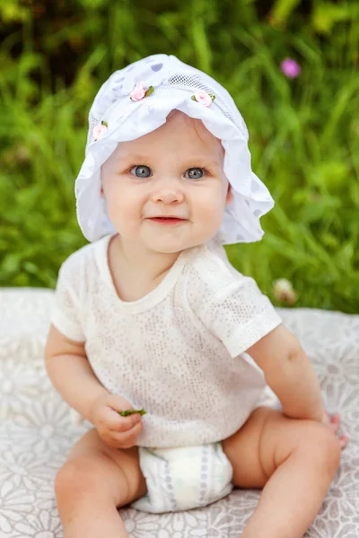 Dolce bambina felice seduta sull'erba nel parco, giardino, prato — Foto Stock