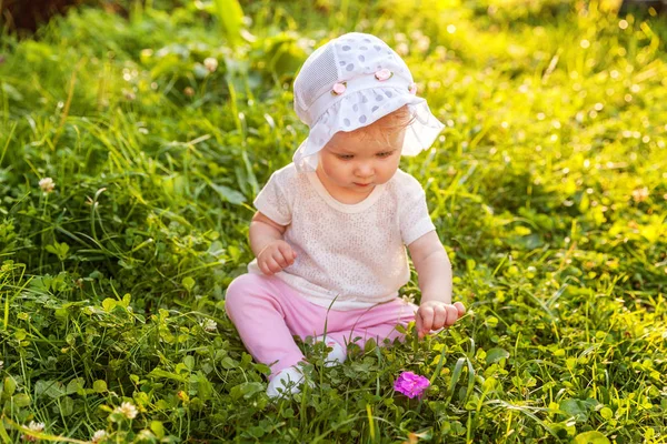 Édes boldog kis baba lány ül a fűben park, kert, rét — Stock Fotó