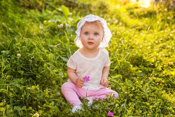 Dolce bambina felice seduta sull'erba nel parco, giardino, prato — Foto Stock