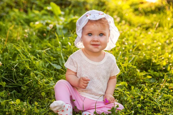 Dolce bambina felice seduta sull'erba nel parco, giardino, prato — Foto Stock