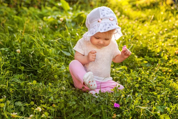 Édes boldog kis baba lány ül a fűben park, kert, rét — Stock Fotó